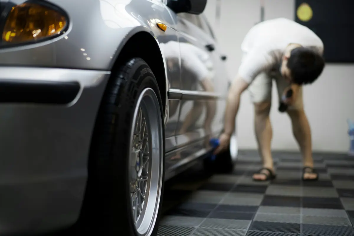 Detailer pere kotač srebrnog automobila